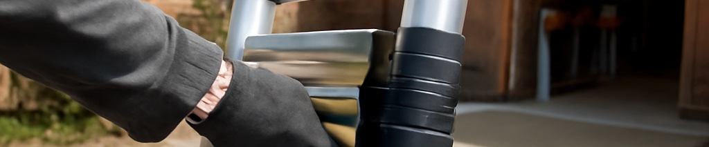 Professioneller Handwerker beim Ausfahren einer hochwertigen Teleskopleiter mit Verriegelung und rutschfesten Füßen